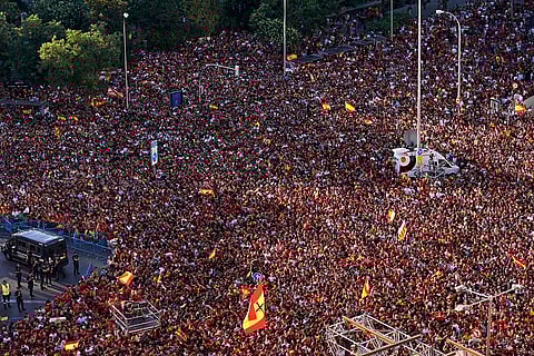 Fans wait for the arrival of the Spanish team at Cibeles square